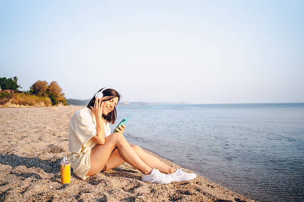 istock A young woman using phone on the sea 2227564863