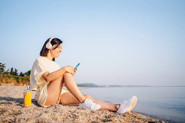 istock Woman using phone on the beach 2227564922