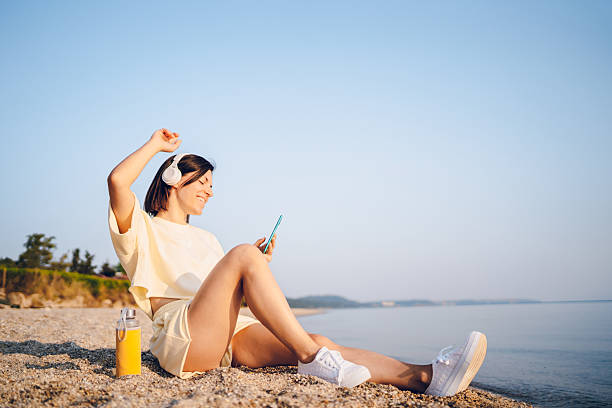 istock A young woman using phone on the sea 2227565613