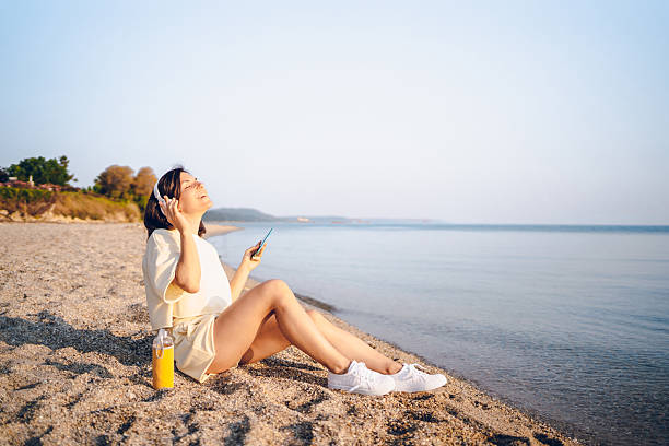 istock A young woman using phone on the sea 2227565672