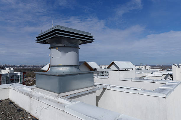 istock Top View of a Modern Rooftop Ventilation System Surrounded by Urban Architecture Under Clear Blue Skies - Architectural Details of a High-Rise Building Rooftop 2227565813