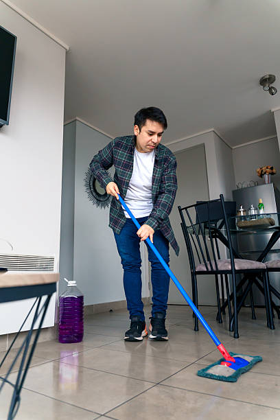 istock Young man mopping the floor in his modern apartment 2227570701