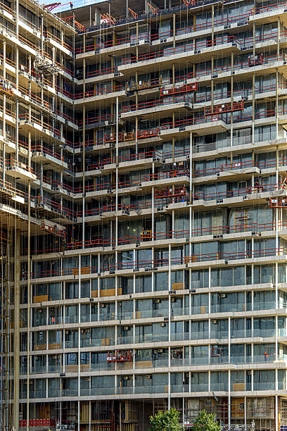 istock A multi-story building with balconies is under active construction, surrounded by scaffolding and equipment. \ 2227572152
