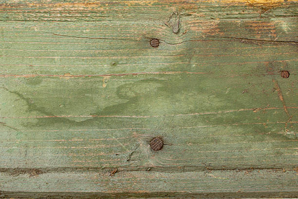istock Green painted obsolete wooden board with rusty nails, abstract retro backdrop 2227573637