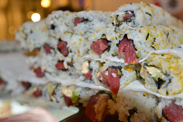 Delicious layers of fresh tuna sushi rolls, prepared with rice, seaweed, and flavorful toppings, are stacked high on a plate, showcasing the artistry of Japanese cuisine