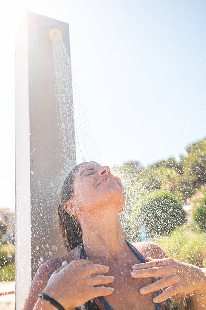 istock Tourist enjoying refreshing shower on the beach during summer vacation 2227580891