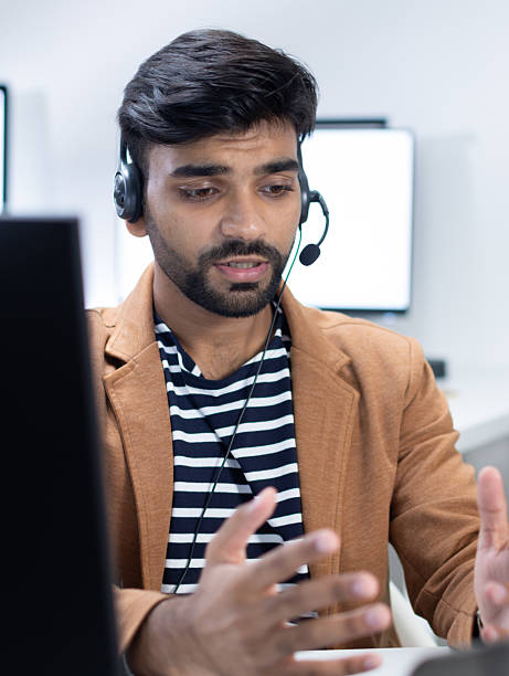 istock Indian Customer Support Agent Wearing Headset While Talking During Online Video Call in Modern Office 2227583053