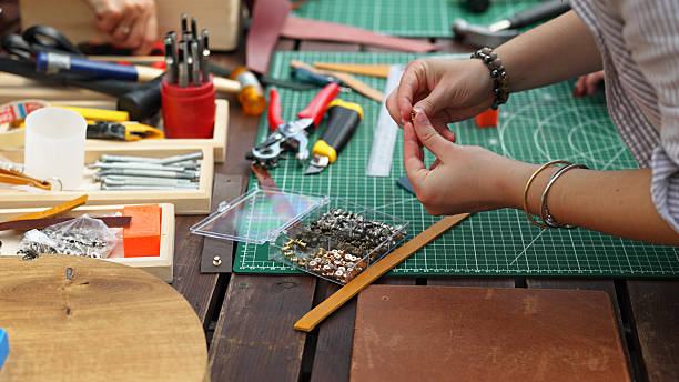 istock Hands working with leather and metal crafting tools. 2227583447