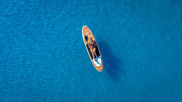 istock Woman relaxing on paddle board in blue water 2227583888