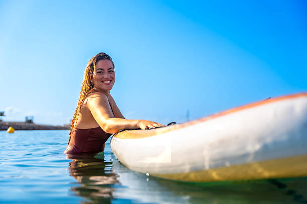 istock Young woman relaxing on paddle board in blue water 2227584555