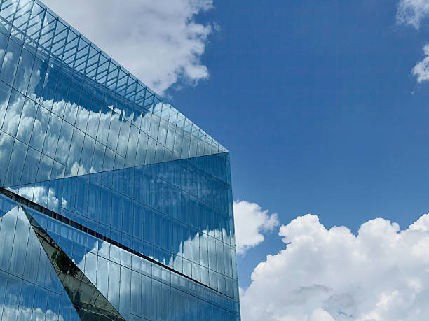 istock Modern glass building reflecting clouds in the blue sky 2227586536