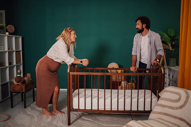 Happy couple admiring their new crib, filled with excitement for the upcoming arrival of their baby and the joys of parenthood
