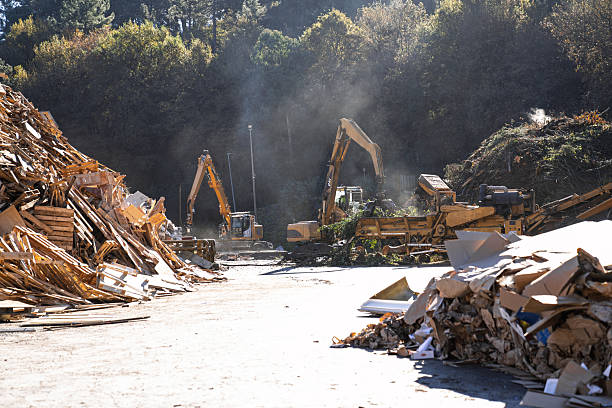istock Excavators sorting wood and cardboard for recycling in waste management facility 2227588757