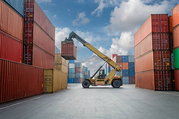 Aerial view of crane lifting up container in commercial port.