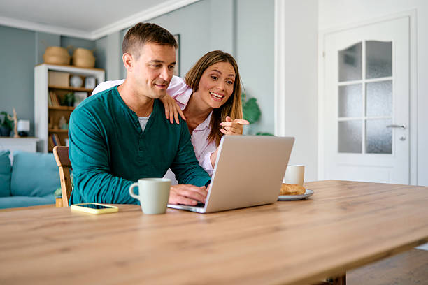istock Happy couple using laptop together in their dining room 2227594815