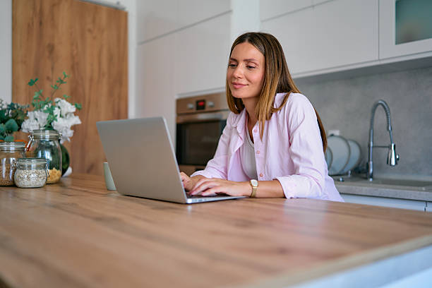istock Young Woman Working From Home on Laptop in Kitchen 2227594939