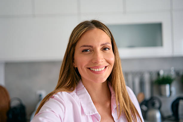 istock Happy woman smiling and taking a selfie in her kitchen 2227594951