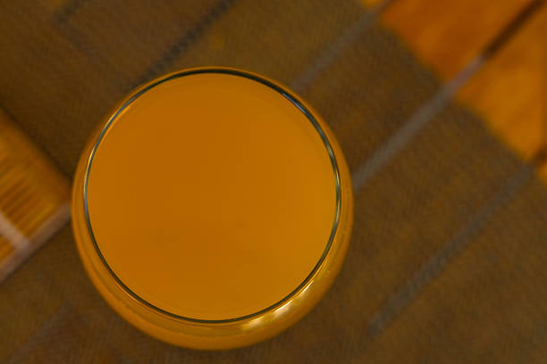 Orange juice poured into a glass placed on the table, a refreshing carbonated drink in a glass