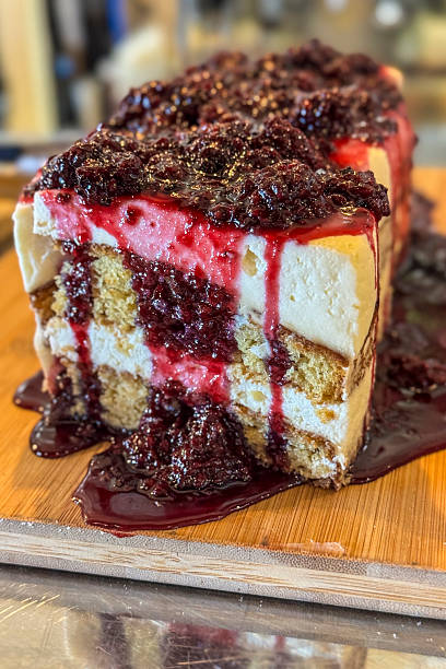 Peace of sponge cake with fresh raspberry and blackberry on wooden table.