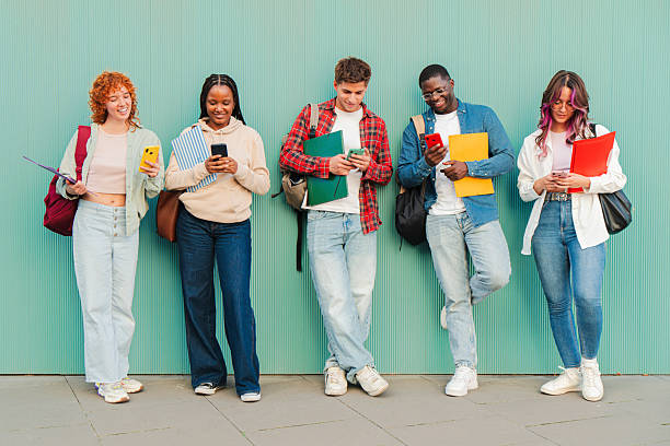istock Diverse group of cheerful students engaging with their smartphones while enjoying each other's company 2227599887