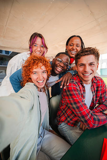 istock Vertical. Happy group of diverse students taking a selfie together, capturing a moment of friendship, teamwork, and fun. Young people. Perfect for education, youth, social media, and group activities 2227600104
