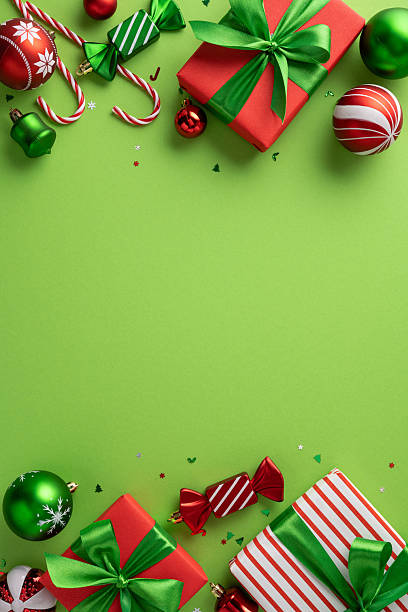 istock Festive vertical composition featuring Christmas presents, candy canes, and baubles on a green backdrop 2227600337