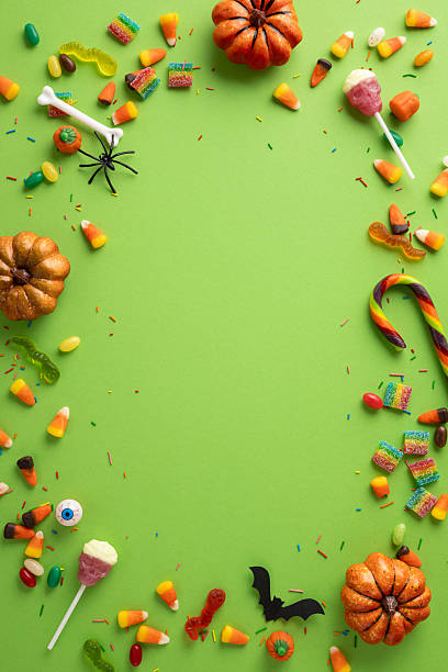 istock Halloween vertical candy and decorations form a vibrant border on a green background, perfect for festive concepts 2227600339