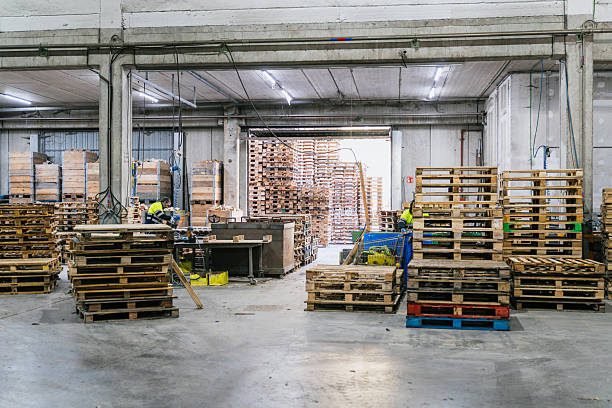 istock Workers sorting wooden pallets in a recycling factory 2227600483