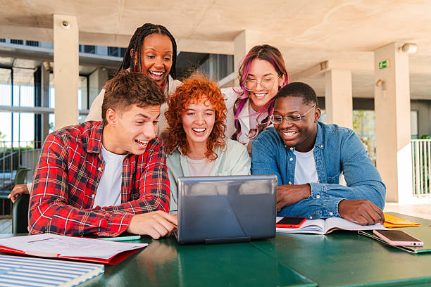 istock Group of university students collaborating on homework together in a library, sharing ideas, using a laptop, studying with books and notes, showcasing teamwork, learning, and academic dedication 2227601509