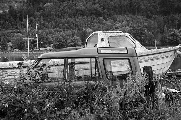 Havana, Cuba - January 25, 2006: Old american cars parked on the road, with crubling houses in la Havana Vieja, Black and White. In the background, people walking o  the street
