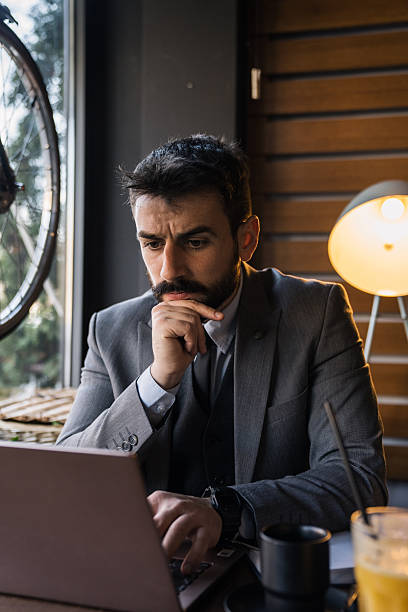 istock Young businessman reading on laptop with serious focus 2227603995