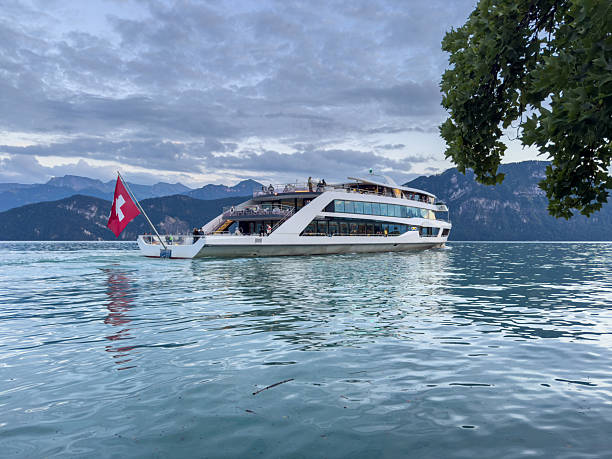 Czorsztyn Lake, Poland – August 5, 2025: A decorated tourist boat sails on the shimmering water surrounded by forested hills. The dramatic summer clouds and reflections create a picturesque travel scene.