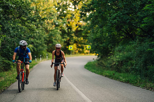istock Cyclists enjoying a summer ride on a winding forest road 2227606081
