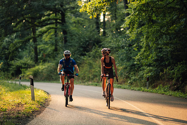 istock Couple cycling on scenic forest road at sunset 2227606082