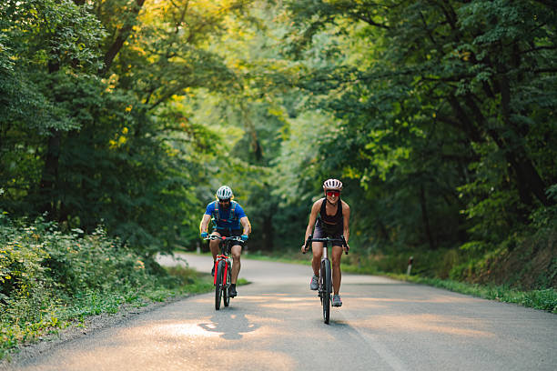 istock Cyclists riding bicycles on scenic forest road at sunset 2227606112