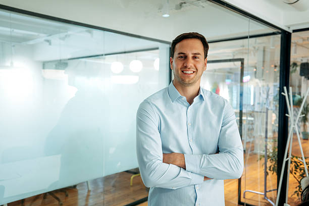 istock Young well-dressed businessman posing in modern boardroom 2227607220
