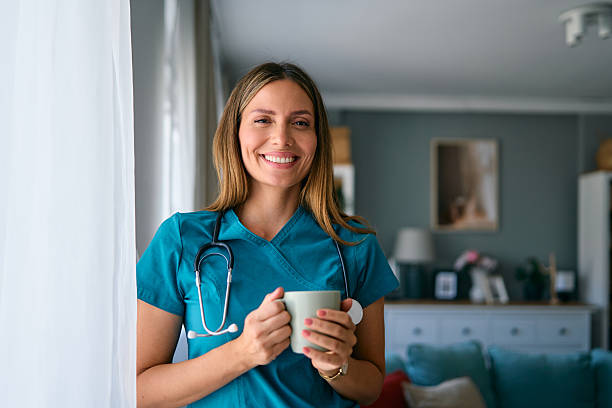 istock Smiling female doctor drinking coffee at home 2227610088