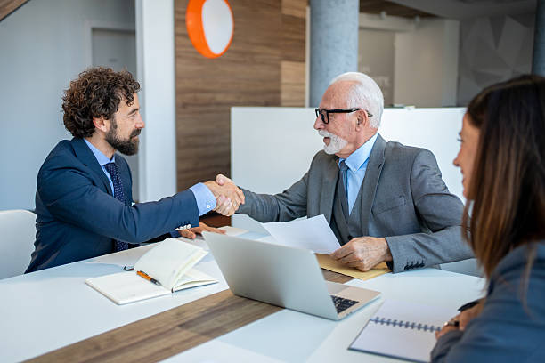 istock Businessmen shaking hands after successful meeting in modern office 2227611422