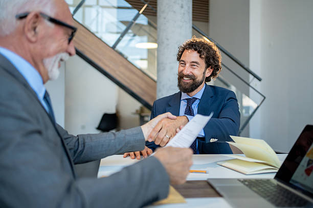 istock Two businessmen shaking hands after signing contract in office 2227611433