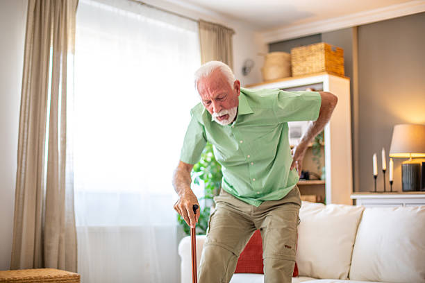 istock Senior man experiencing back pain while sitting down on sofa at home 2227611828
