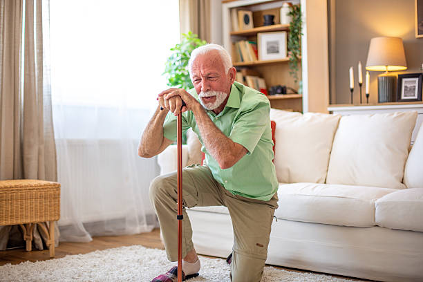 istock Senior man kneeling on floor holding walking cane 2227611833