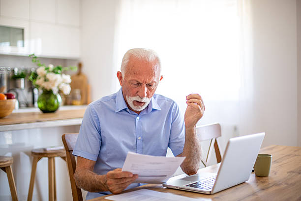 istock Senior man using laptop and calculating home bills 2227612196