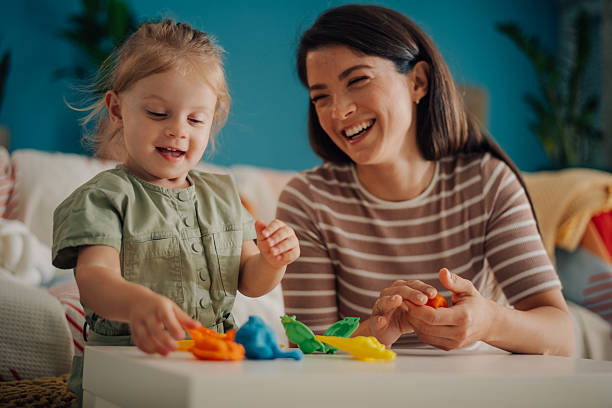 istock Mother and daughter playing with modeling clay at home 2227612622