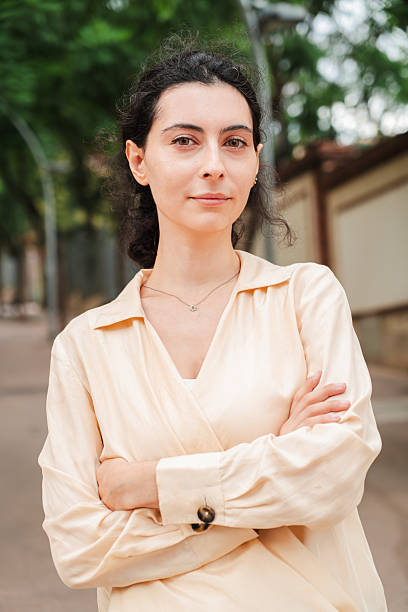 istock Vertical. Young woman looking pensive at camera, standing on an empty street, reflecting a serious mood and contemplative expression in an outdoor urban, suggesting thoughtfulness and introspection 2227613412