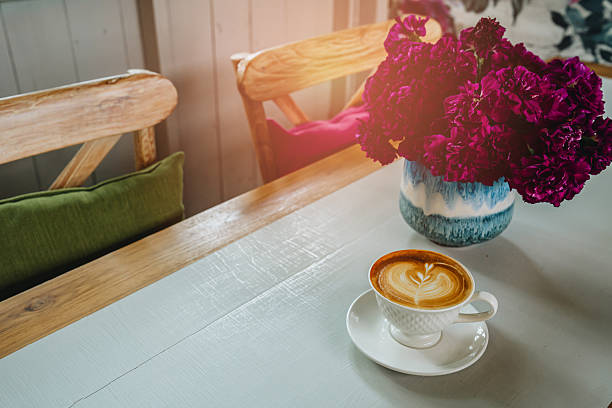 Cozy Coffee Moment with Flowers on Wooden Table.