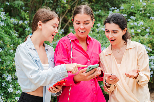 istock Three enthusiastic women sharing excitement while browsing apps on their smartphones in a joyful moment 2227615790