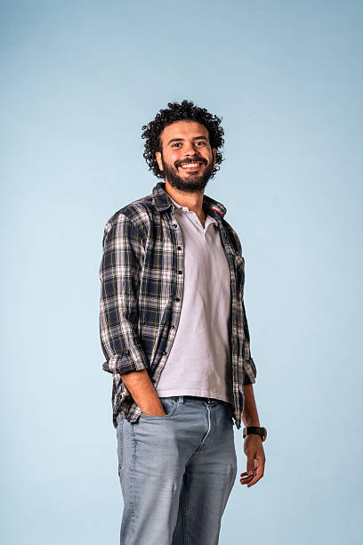 istock Confident Middle Eastern Man Smiling in Casual Outfit Against Soft Blue Background 2227617731