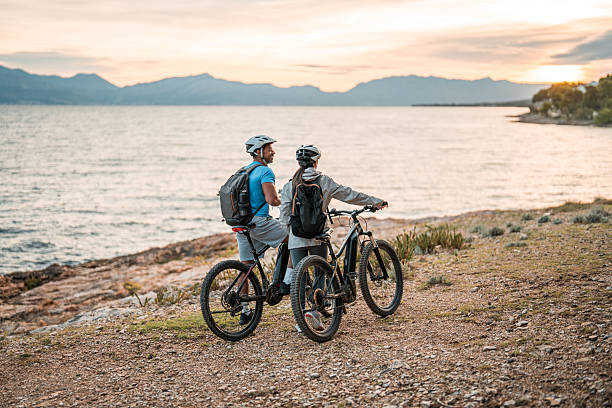 istock Diverse Couple with E-Bikes at Coastal Sunrise 2227617872