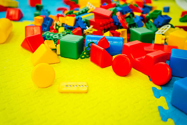 Colorful building blocks scattered on a bright play mat, creating a playful atmosphere in a children's playroom.