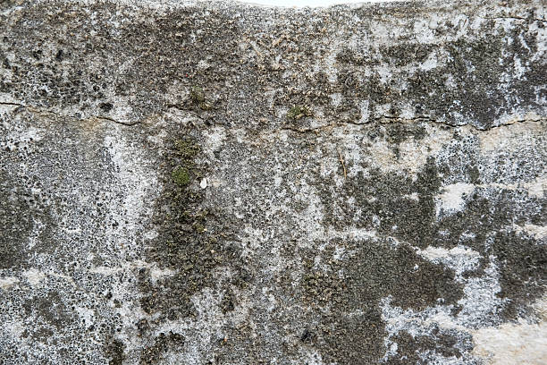 Weathered and cracked concrete wall, displaying age and texture. backgrounds or urban themes